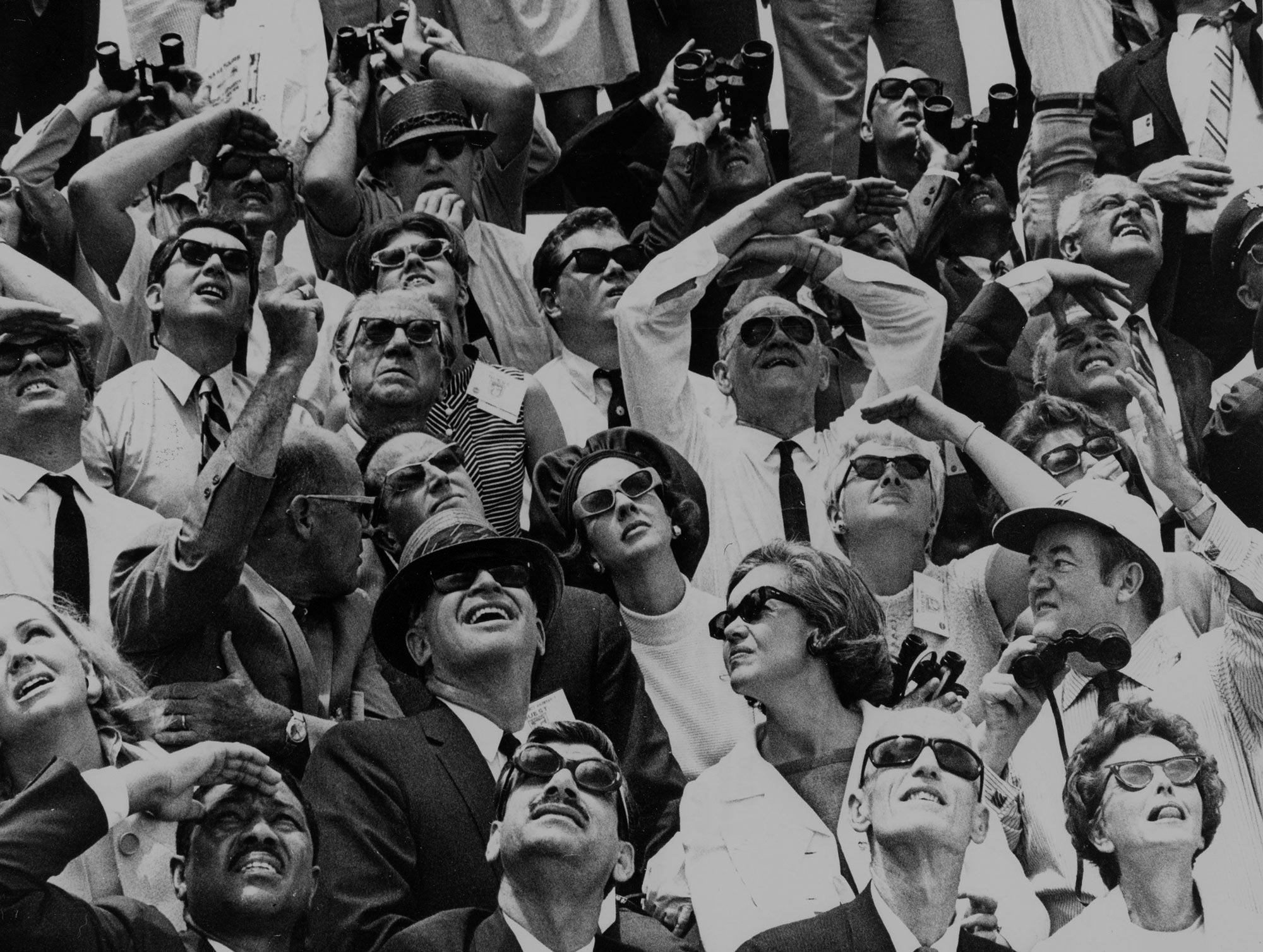 vintage photo of a crowd watching an eclipse with special sunglasses