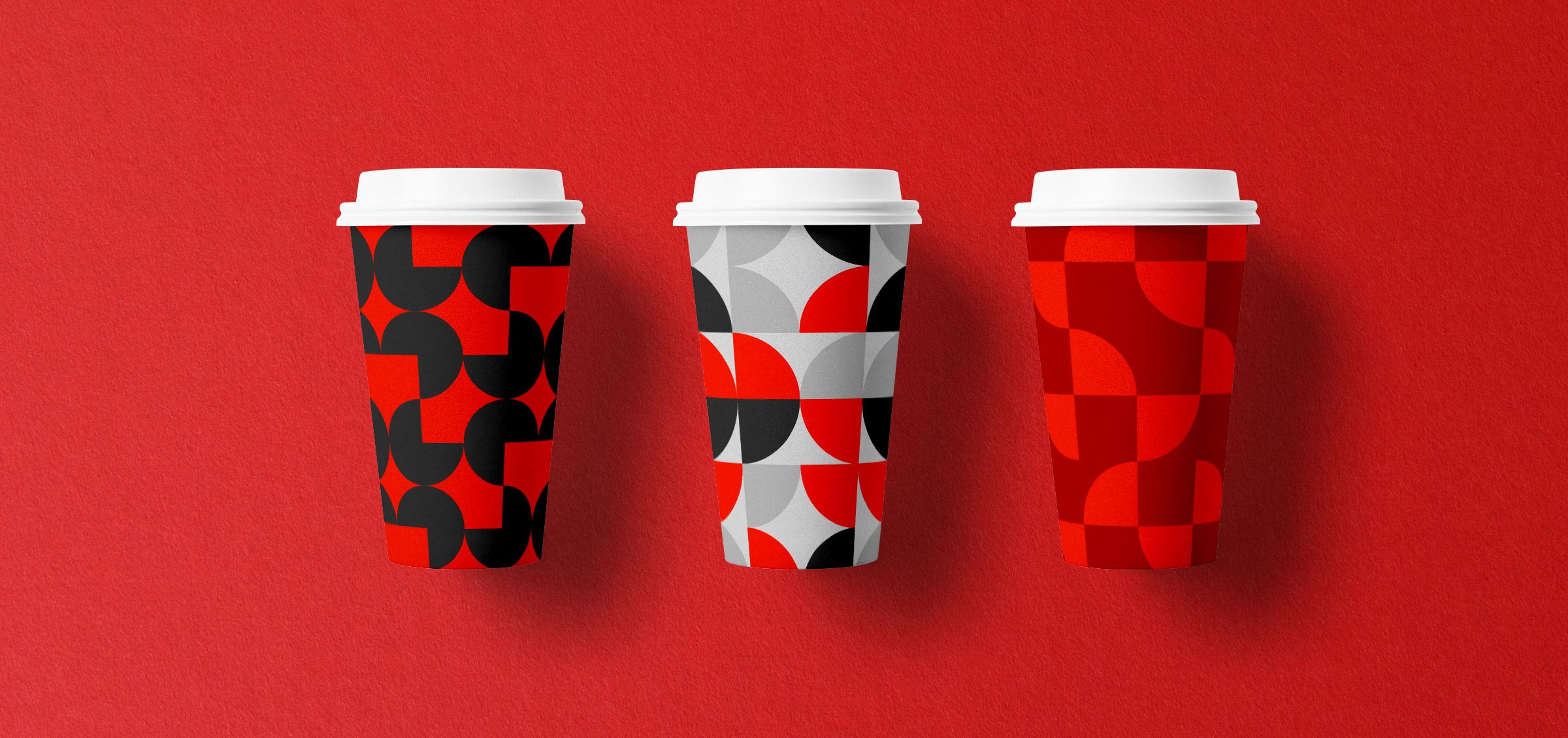3 coffee cup designs with soren west patterns in red, black and gray on red