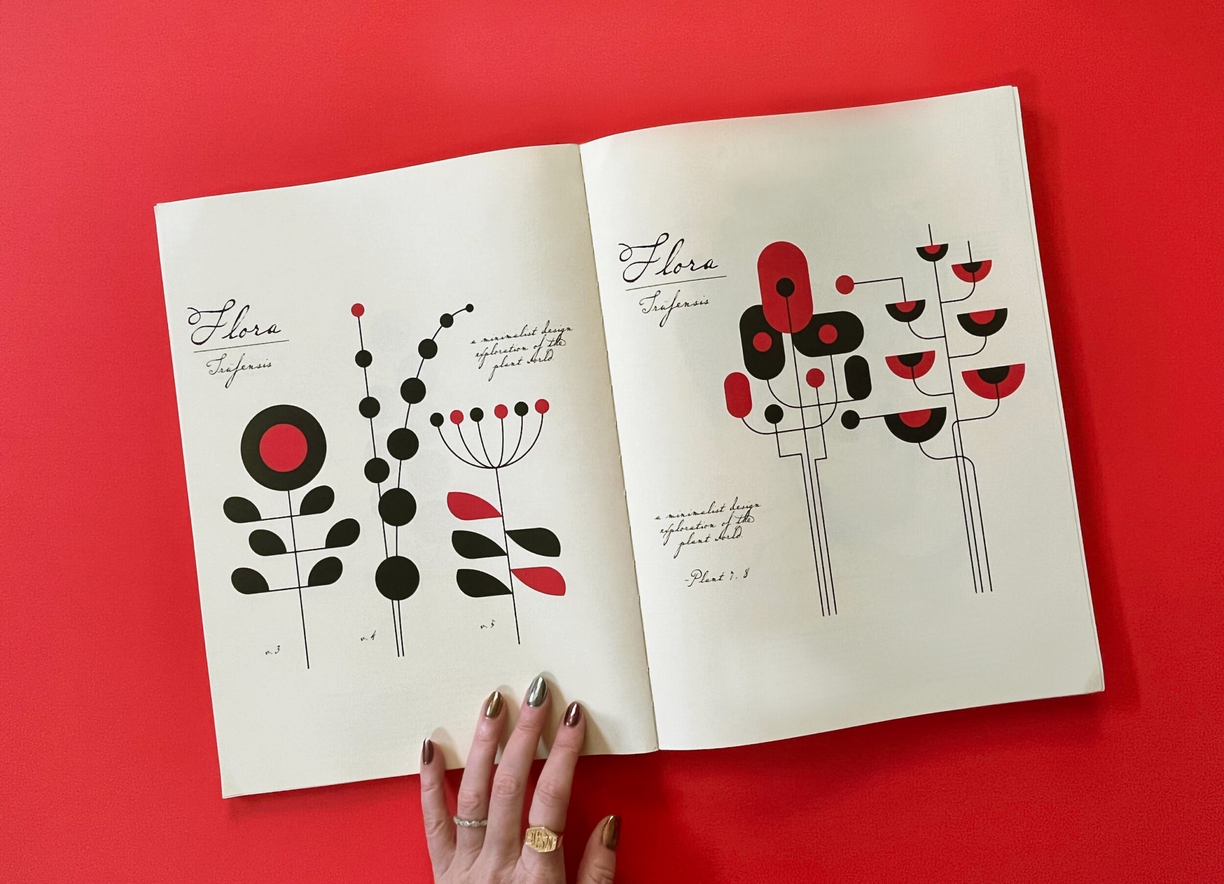 hand holding open spread of 24 ore cultura herbaria magazine with black and red flora illustrations