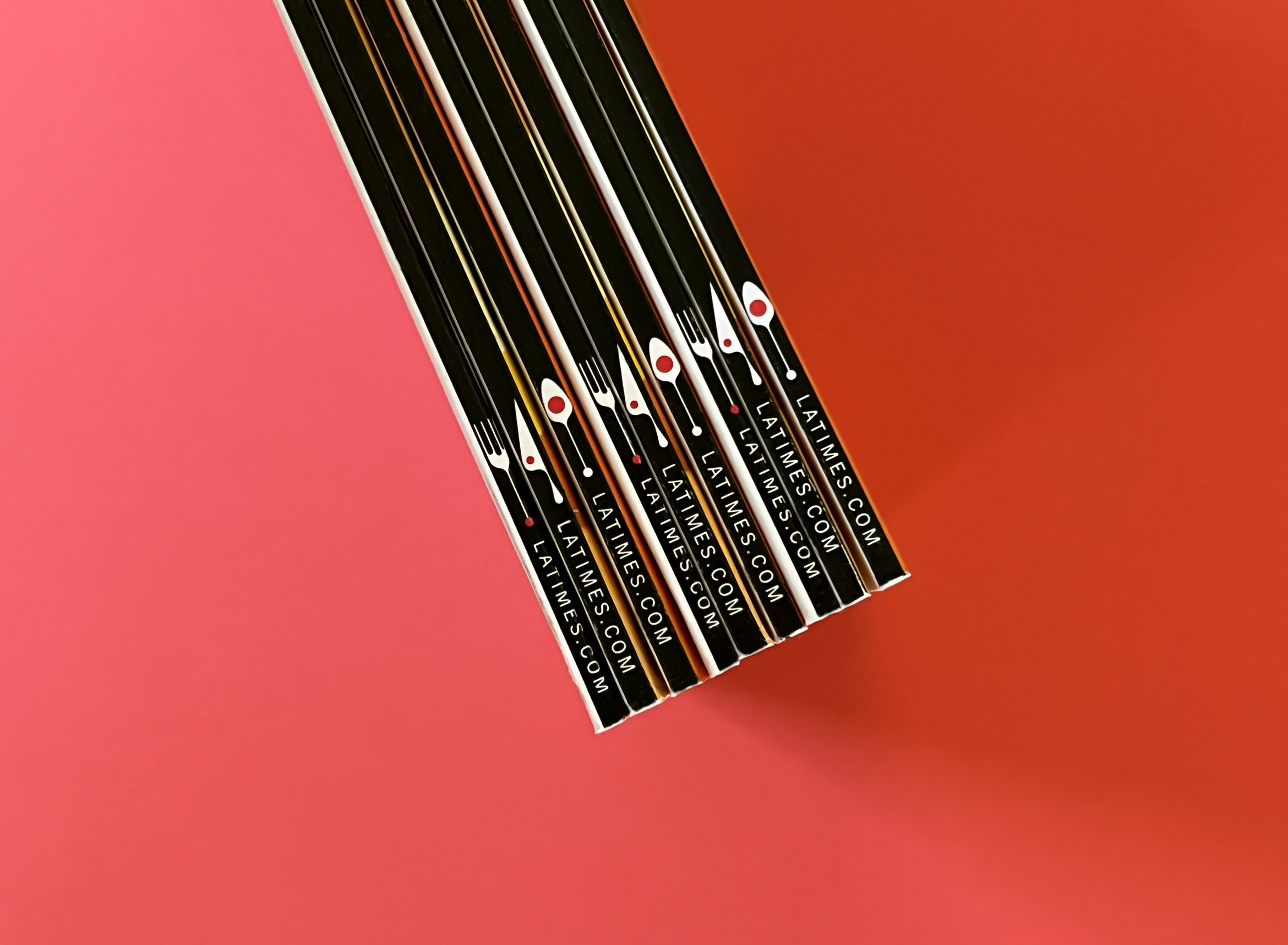 stack of black spines of la times 101 best magazines on red backdrop