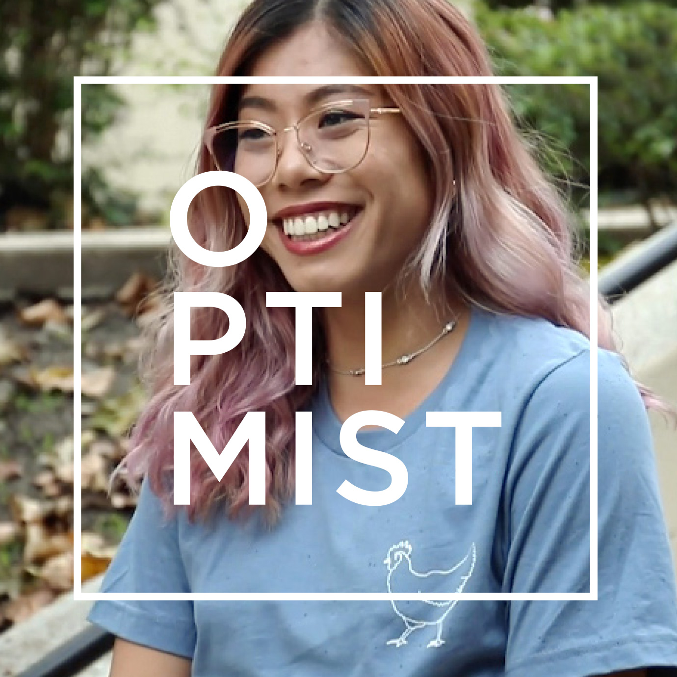 asian woman wearing a light blue optimist shirt with square outline optimist logo on top