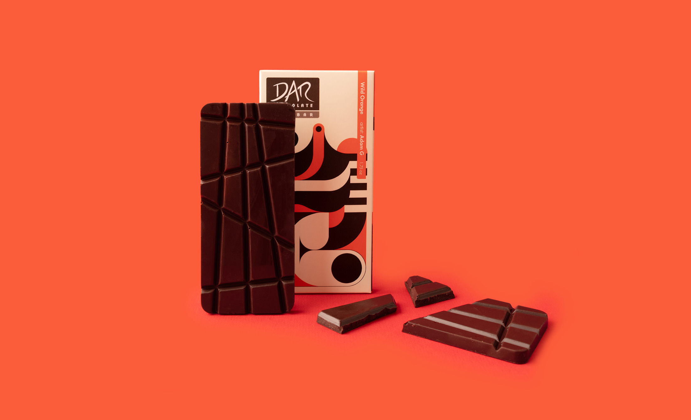 DAR chocolate bar in front of its packaging with 23 design and pieces of chocolate on orange baccground