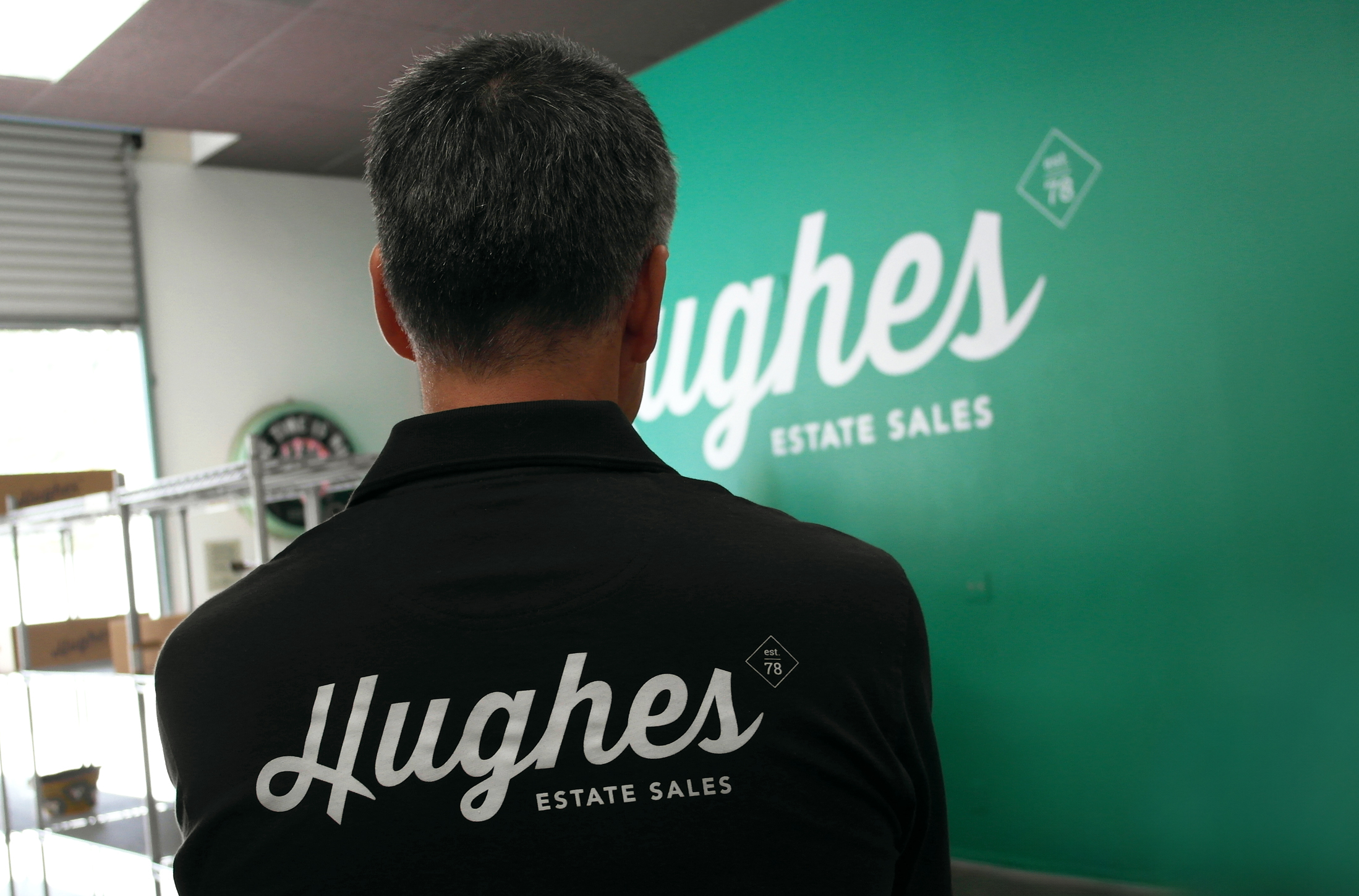 hughes logo white on a black shirt inside the showroom